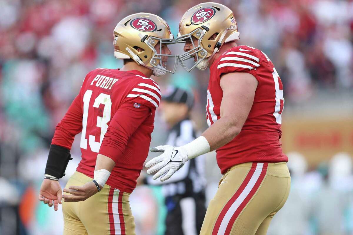 Brock Purdy, the 49ers’ third-string quarterback but also their new starter, celebrates a touchdown pass to Christian McCaffrey with Daniel Brunskill.