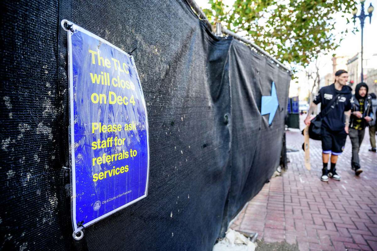 A sign announcing the closing of the Tenderloin Center, which provided services for drug users and the homeless, hangs on a fence.