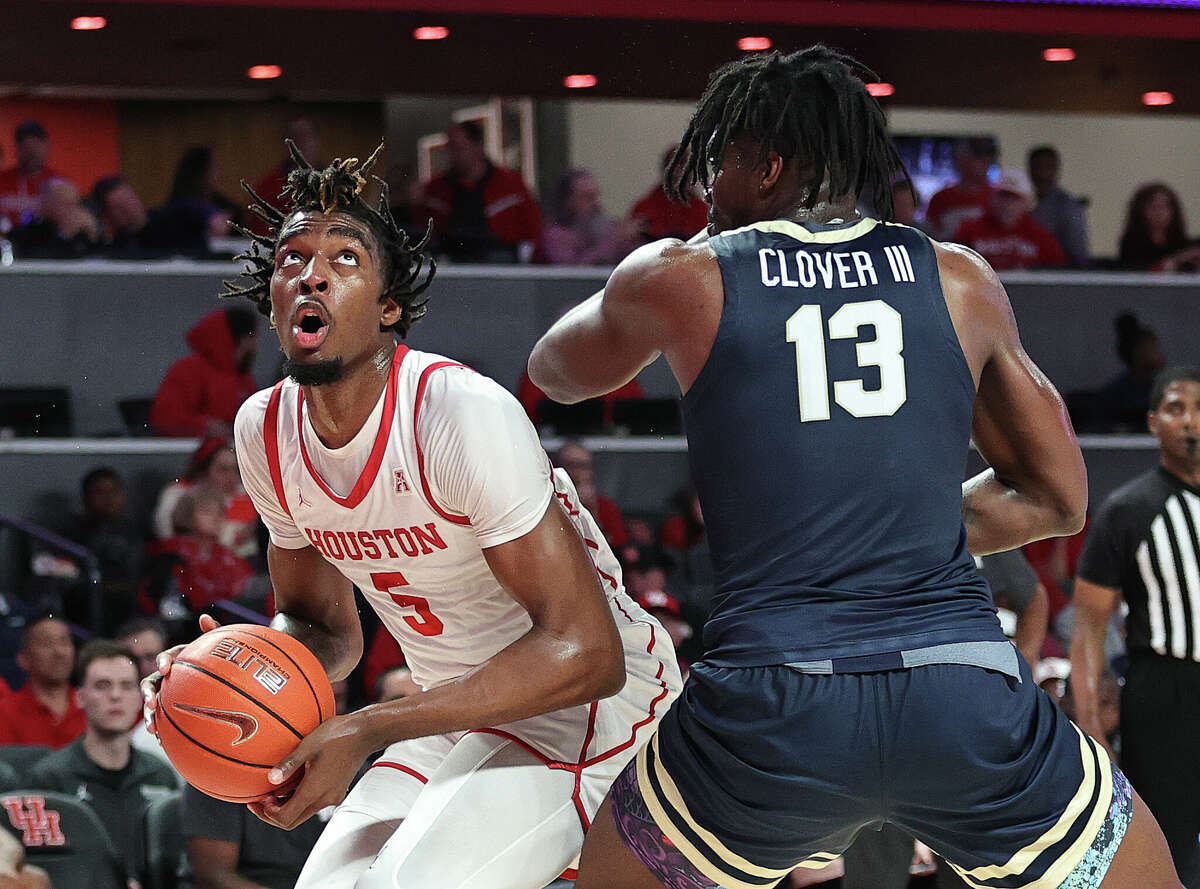 Ja'Vier Francis #5 of the Houston Cougars drives to the basket on Nate Clover III #13 of the Oral Roberts Golden Eagles at Fertitta Center on November 14, 2022 in Houston.