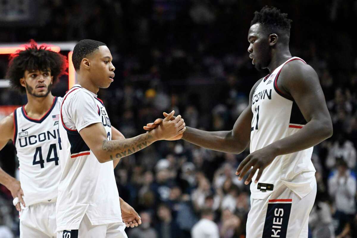 Connecticut's Jordan Hawkins and Adama Sanogo shake hands at the end of an NCAA college basketball game against Oklahoma State, Thursday, Dec. 1, 2022, in Storrs, Conn.