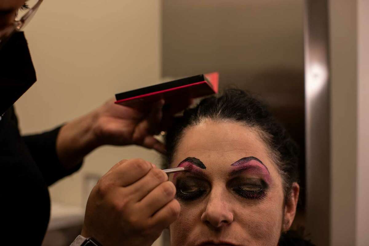 Sabrina Lopez, 34, applies stages make up to Tamara Adira, 53, one of the people playing the role of Mother Ginger in the San Antonio Ballet' production of "The Nutcracker."  