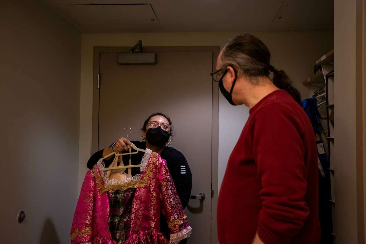 Sabrina Lopez, 34, shows Nathan Cone, 49, the top half of the Mother Ginger costume backstage at the Tobin Center for the Performing Arts. Ballet San Antonio has cast community heroes in the role.  