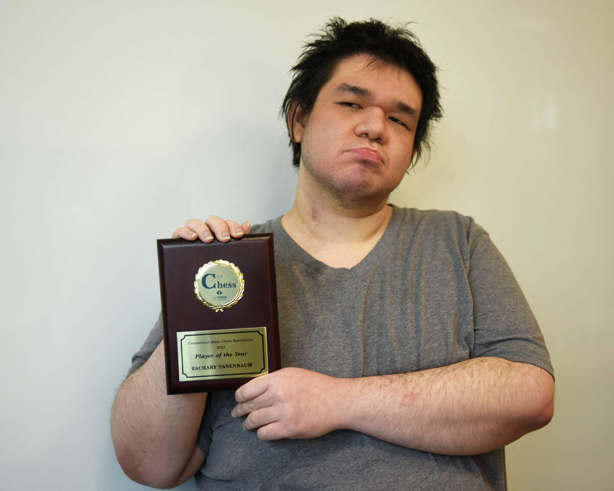 Glenville resident Zachary Tanenbaum, 22, poses with his Connecticut State Chess Association 2022 Player of the Year award at Greenwich Library in Greenwich, Conn. Monday, Dec. 5, 2022.