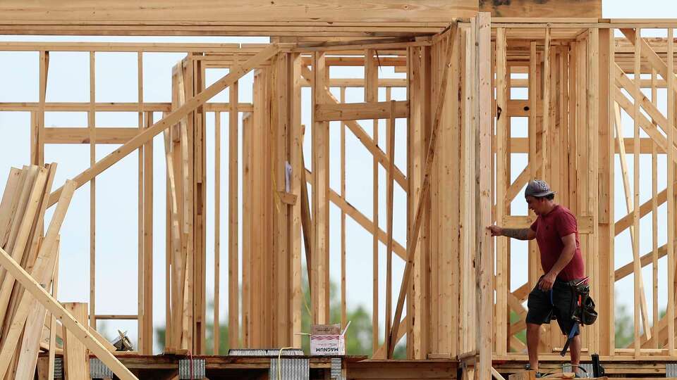 A man works on framing of a home in a subdivision near Texas 242 and F.M. 1314, Wednesday, Aug. 24, 2022, in Conroe.