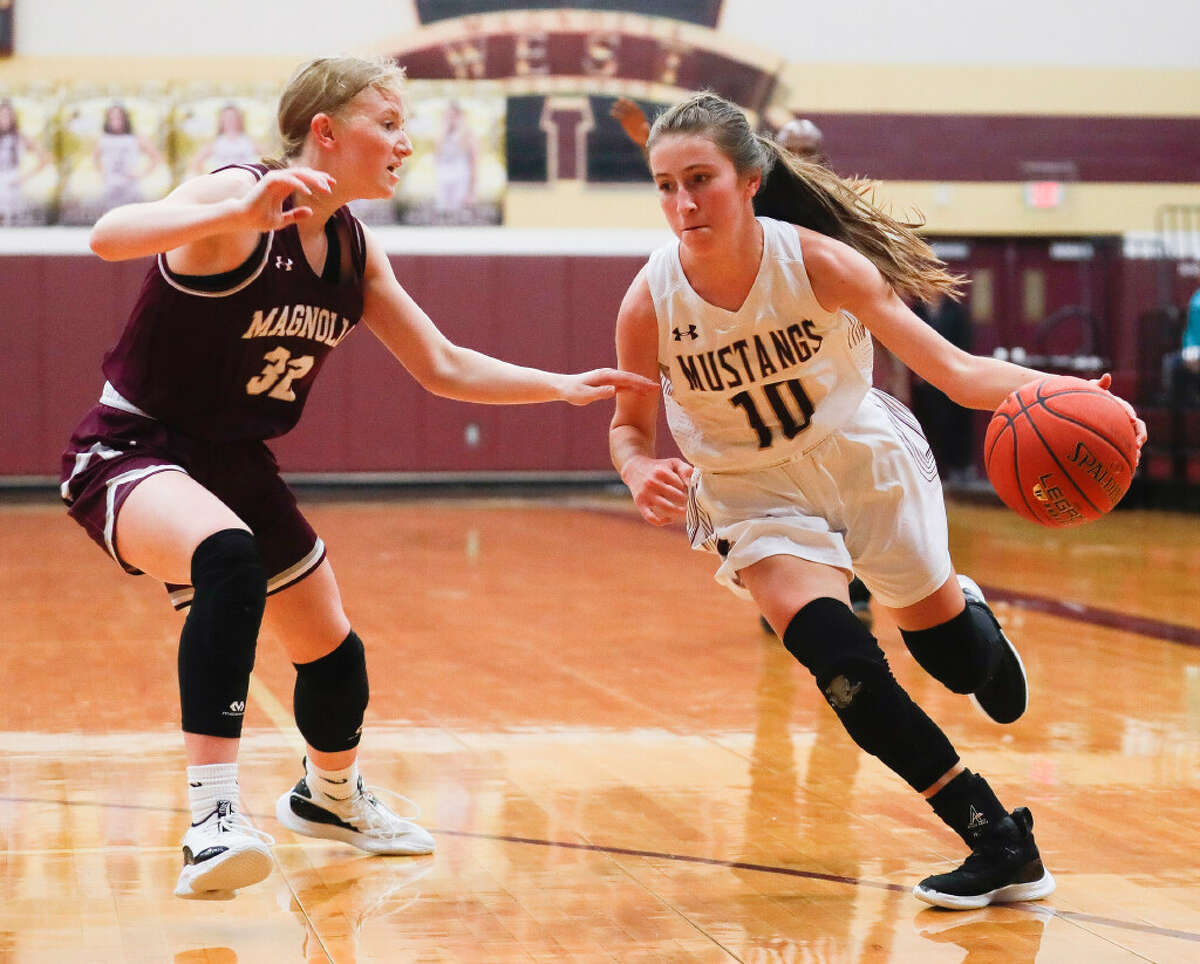 Magnolia's Emma Rowan (32), left, defends Magnolia West's Faith Matocha (10) during the first quarter of a high school basketball game at Magnolia West High School, Tuesday, Jan. 4, 2022, in Magnolia.