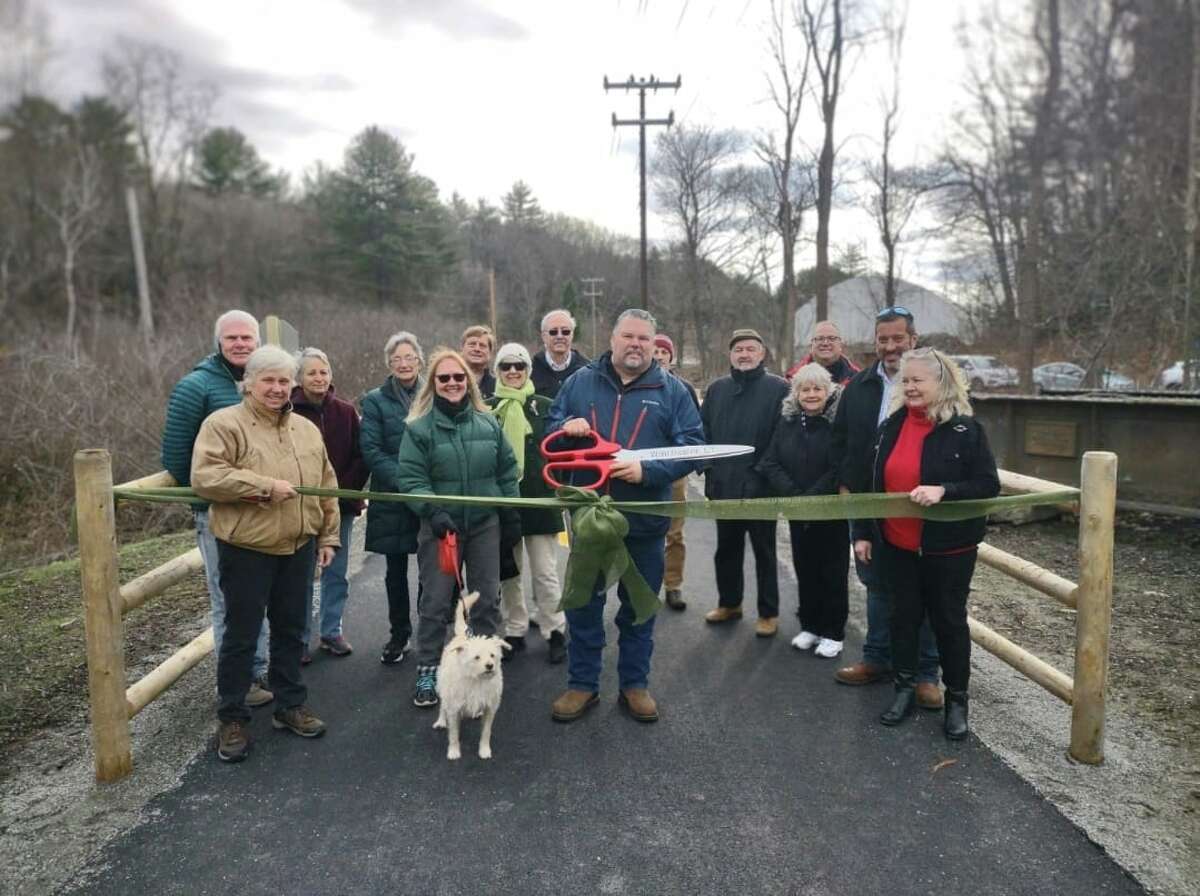 Residents, town officials and town staff celebrate the official opening of and ribbon-cutting for the Sue Grossman Greenway extension, recently completed in Winsted. 