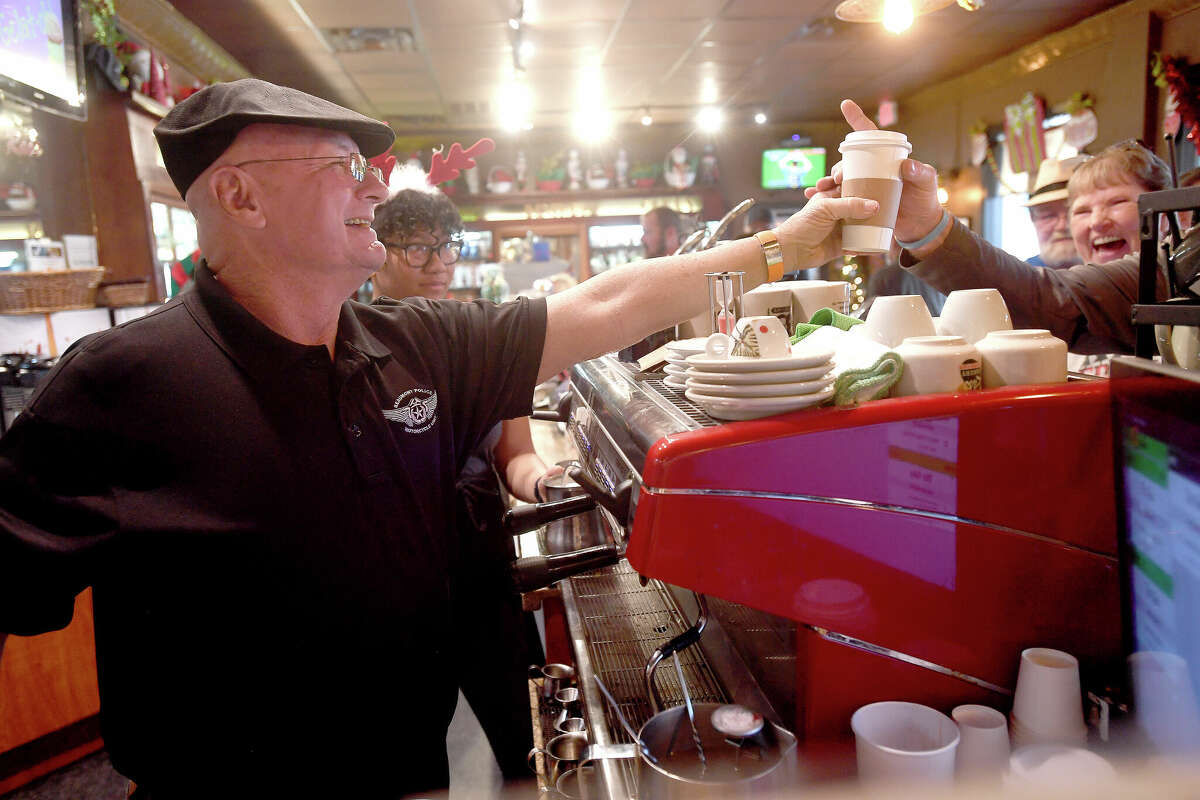 Beaumont Police Officer Kolin Burmaster makes up drink orders during his retirement party at Rao's on Calder Avenue Monday. He spent the morning serving up coffees instead of traffic tickets while trading in his motorcycle helmet for a Rao's cap and working as a barista. Photo made Monday, December 5, 2022 Kim Brent/Beaumont Enterprise