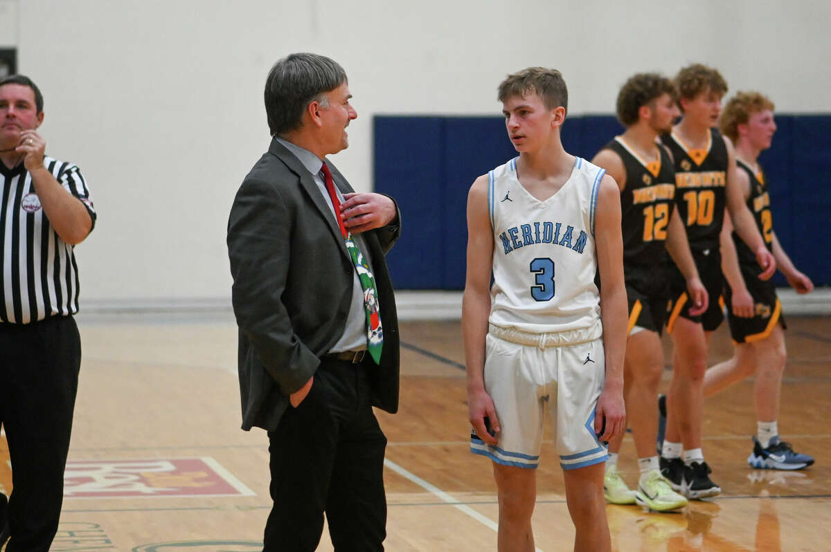 Meridian coach Mitch Bohn talks with Ethan Wetzel during Monday's game against Ogemaw Heights, Dec. 5, 2022.