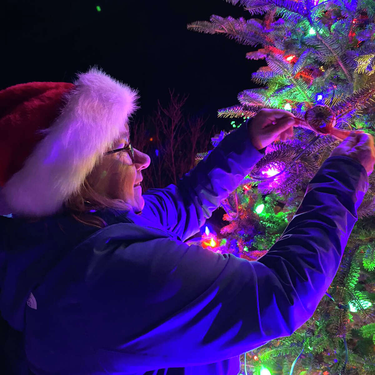Baldwin hosted its first Christmas light parade, tree lighting Dec. 2. Sue Ann Crawford ties a ribbon to the community tree for a Christmas blessing. 