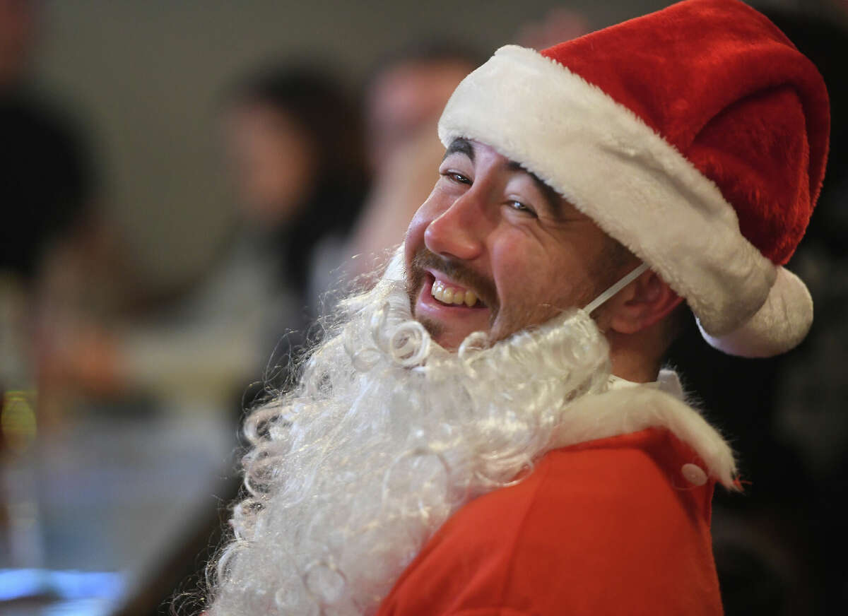 Visiting family in Shelton for the holidays, Riley Casey, of Arizona, participates in the second annual SantaCon pub crawl at Eli's Tavern in Milford, Conn. on Thursday, Dec. 23, 2021.