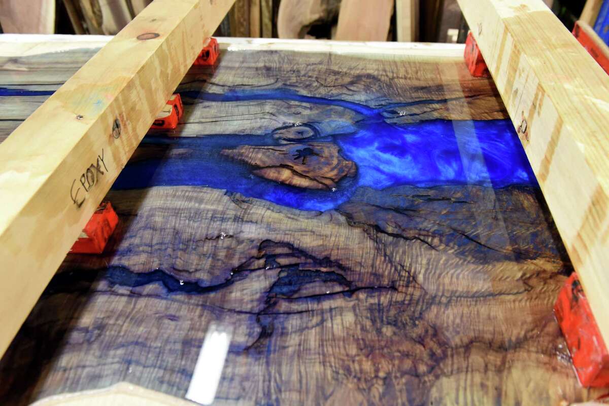A table top is decorated with resin at the Urban Industrial Design workshop on Tuesday, Dec. 6, 2022, in Colonie, N.Y. The local woodworking company is known for their tables/desks/furniture, but also teach classes.