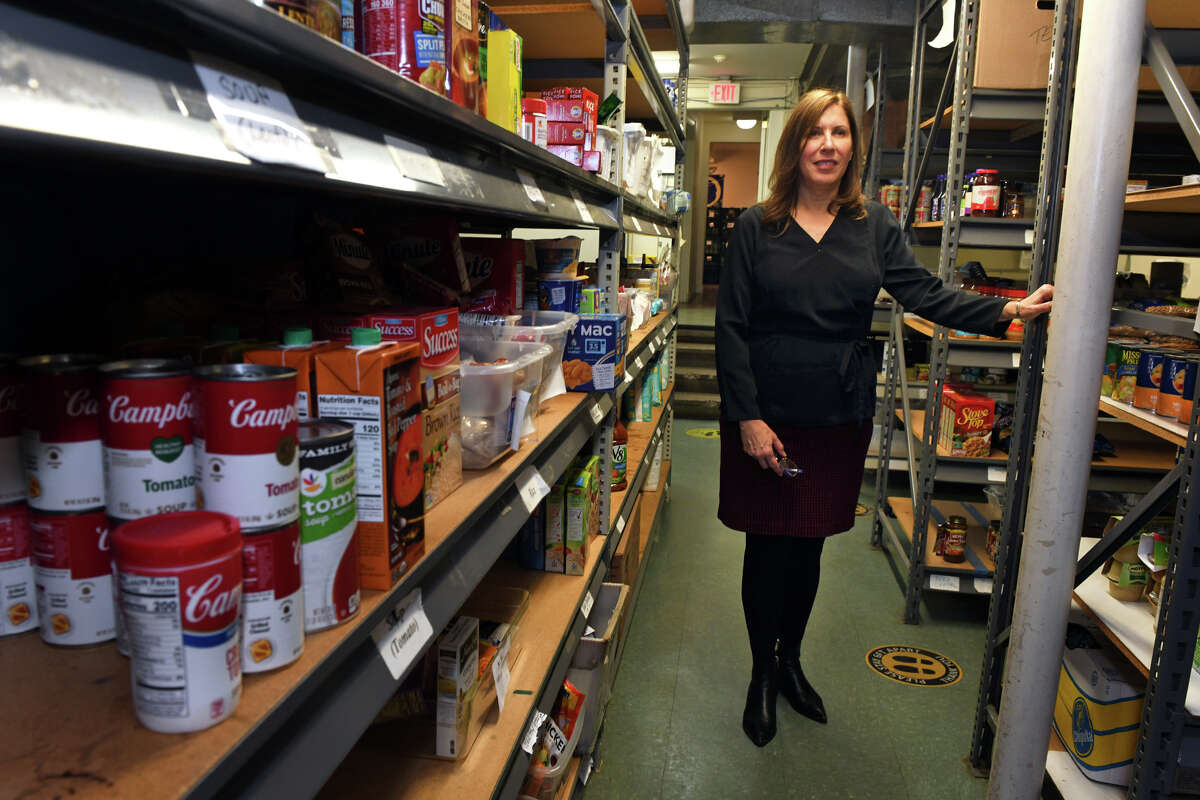 Executive director Carla Miklos poses in Operation Hope’s food pantry, in Fairfield, Conn. Dec. 6, 2022.