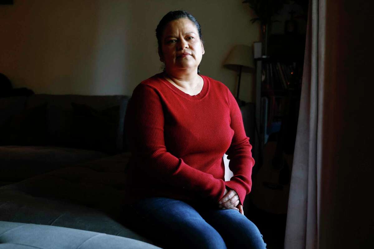 Gregoria Ramirez sits in the living room of her home of 16 years in Napa, Calif. Tuesday, Nov. 1, 2022. Gregoria lost her husband Rodrigo Ramirez to cancer in late 2021. As the anniversary of Rodrigo Sr.’s passing approaches, Gregoria and her son Rodrigo Jr., 19, are still mourning and recovering from their losses. Rodrigo Jr. has a part-time job and Gregoria is looking to work the harvest season again in the vineyards.