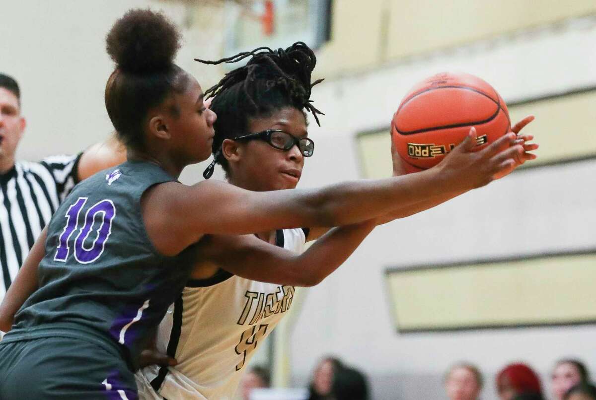 Conroe's Alana Harris (4) is pressured by Willis' Trrinity Davis (10) during the second quarter of a District 13-6A high school basketball game at Conroe High School, Tuesday, Dec. 6, 2022, in Conroe.