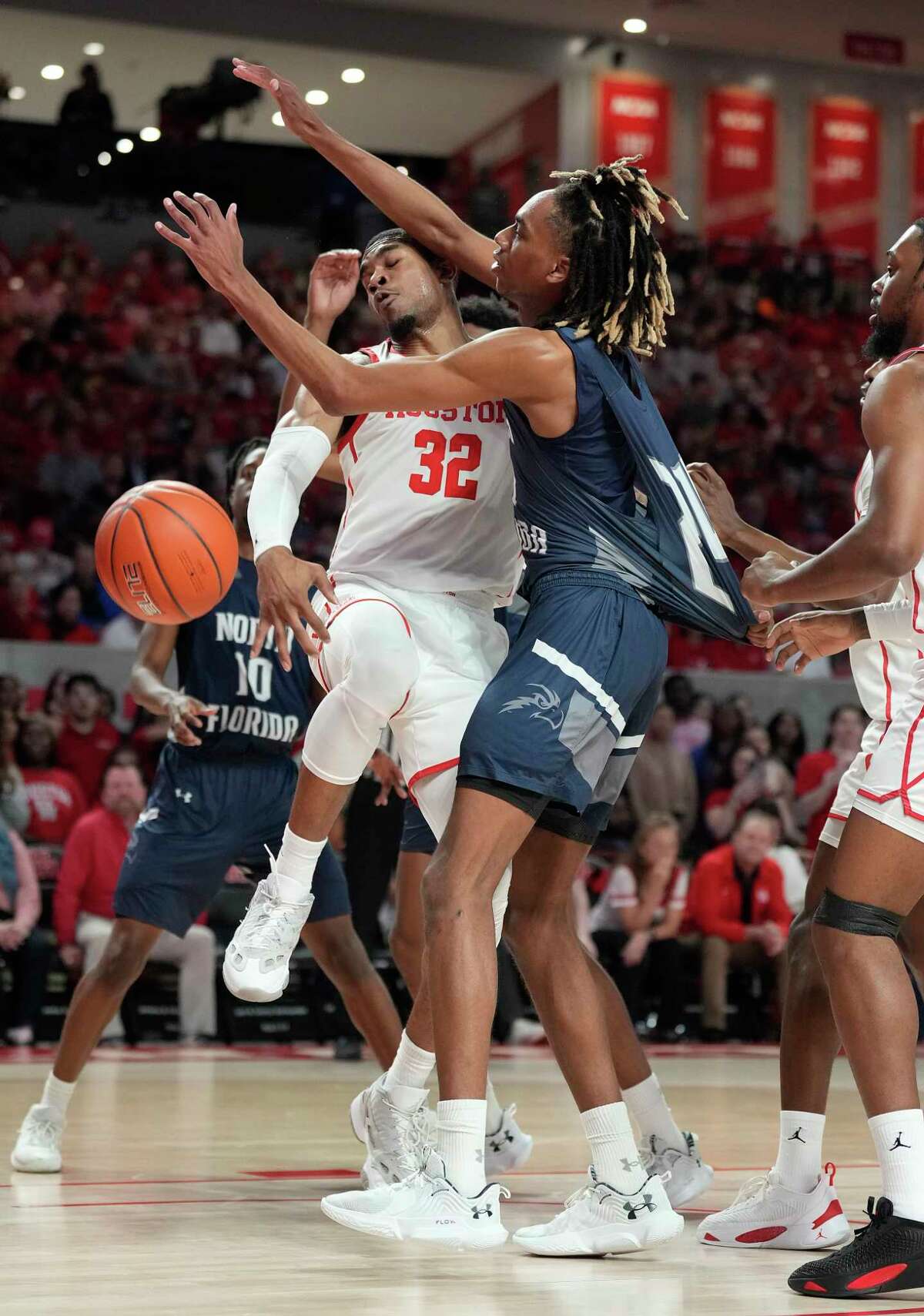 Houston Cougars forward Reggie Chaney (32) battles with North Florida Ospreys forward Jadyn Parker (24) during the first half of an NCAA men’s basketball game at the Fertitta Center on Tuesday, Dec. 6, 2022 in Houston.