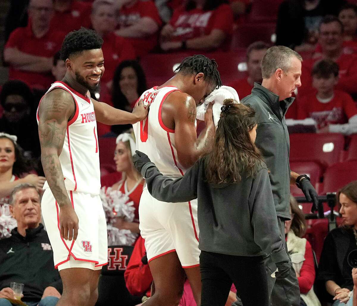UH guard Marcus Sasseris helped off the court by a trainer after he sustained an injury to his face during the first half of Tuesday's game against North Florida.