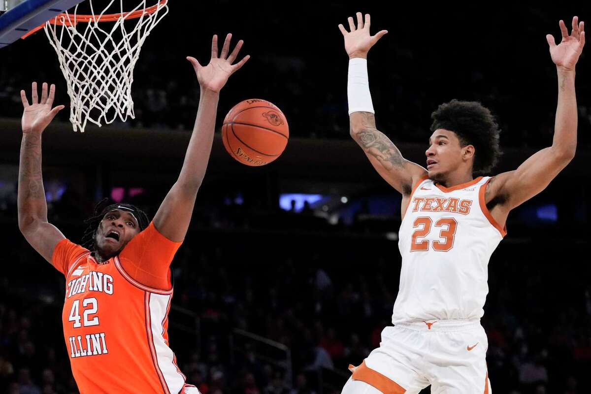 Texas' Dillon Mitchell (23) fouls Illinois' Dain Dainja (42) during the second half of the team's NCAA college basketball game in the Jimmy V Classic, Tuesday, Dec. 6, 2022, in New York.