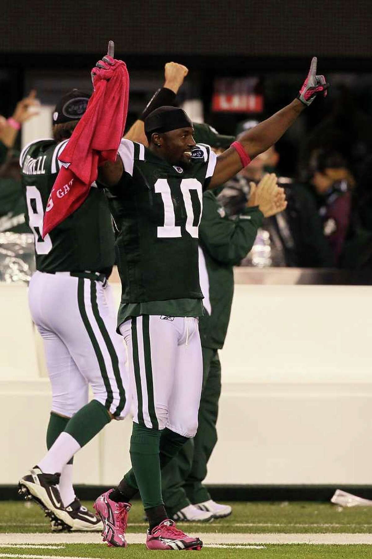 EAST RUTHERFORD, NJ - OCTOBER 11: Santonio Holmes #10 of the New York Jets celebrates as Dwight Lowery #26 scored on a 26-yard interception return for a touchdown in the fourth quarter against the Minnesota Vikings at New Meadowlands Stadium on October 11, 2010 in East Rutherford, New Jersey. (Photo by Jim McIsaac/Getty Images) *** Local Caption *** Santonio Holmes