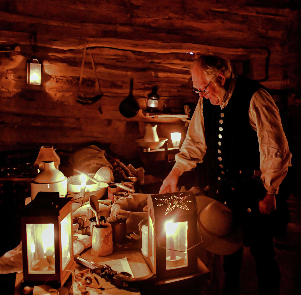 Volunteer Lewis Neely demonstrated the preparation process for a traditional Christmas dinner in the 1838 El Capote Cabin at the National Ranching Heritage Center during Candlelight at the Ranch. (Photo by John Weast)