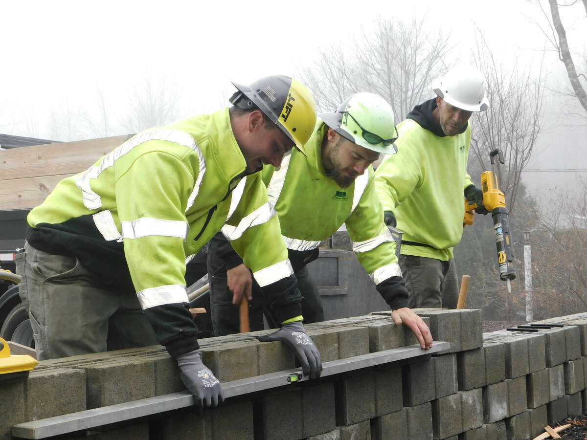 William Bentley, Cody BeBault and Carlos Hernandez work on a retaining wall at a B&D Landscaping job site.