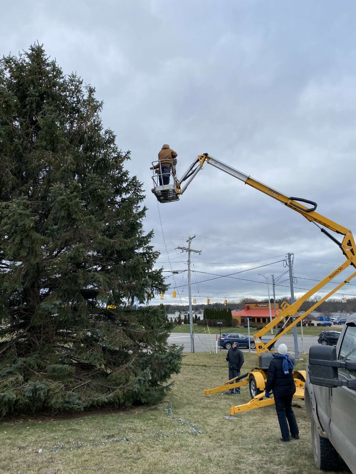 Employees from Authentic 231 and Heritage Farms decorate an evergreen in Filer Township. 
