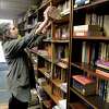 Paige Newman, of Bethel, stacks books on the shelves of Relay Bookhouse for the stores liquidation sale. Windy Cats Estate Sales which is handling the sale. Owner Joel Orton recently died. Wednesday, December 7, 2022, Bethel, Conn.