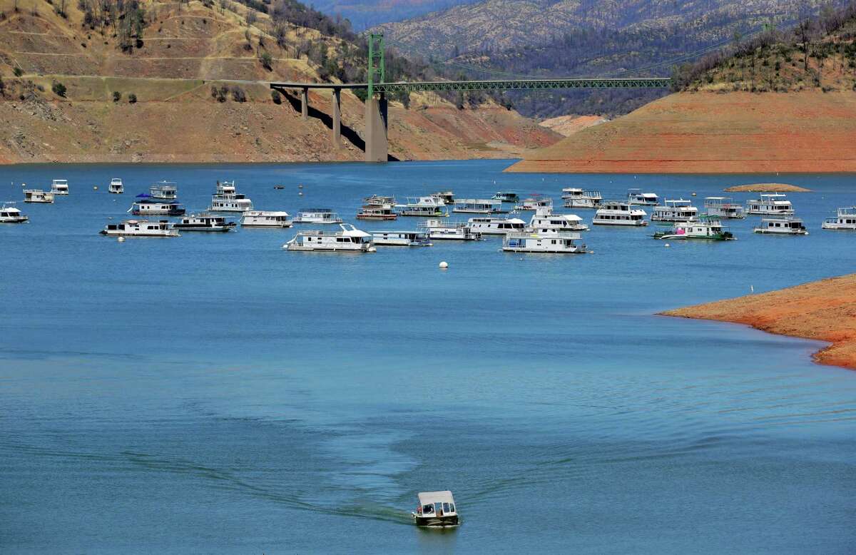 A boat approaches the boat launch as houseboats float on Lake Oroville on June 28.