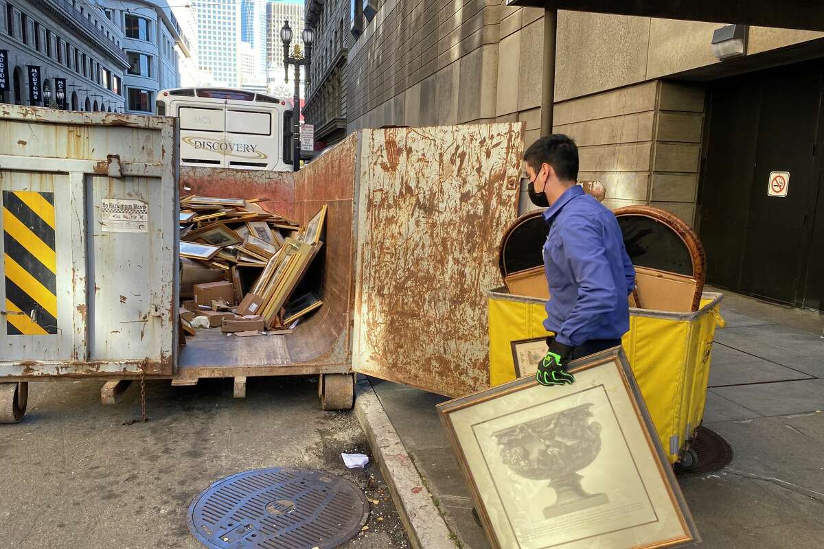 Ricardo Negrete loads the Westin St. Francis' historic artwork into a dumpster.