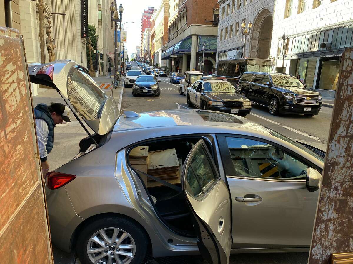 Craig Canon loads his hatchback with several framed photos from the Westin St.  Francis.