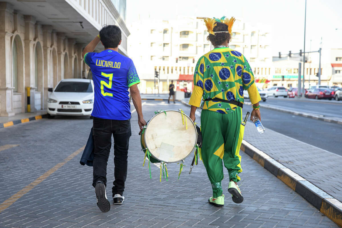 Lucivaldo Costa, left, helps carry Wallace Leite's drum to the Doha Metro before the Brazil-Switzerland World Cup game in Doha, Qatar, on Nov. 28.