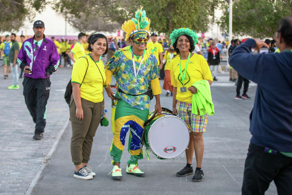 Brazilian Wallace Leite (center) poses with two soccer fans outside Stadium 974 before the Brazil and Switzerland World Cup game in Doha, Qatar on November 28, 2022.