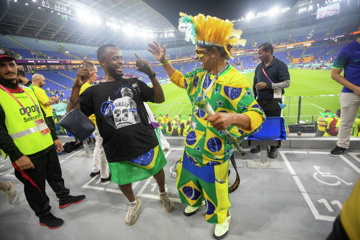 Brazilian Wallace Leite (right) shares a laugh with a soccer fan after the Brazil and South Korea World Cup game at Stadium 974 in Doha, Qatar on December 5, 2022.