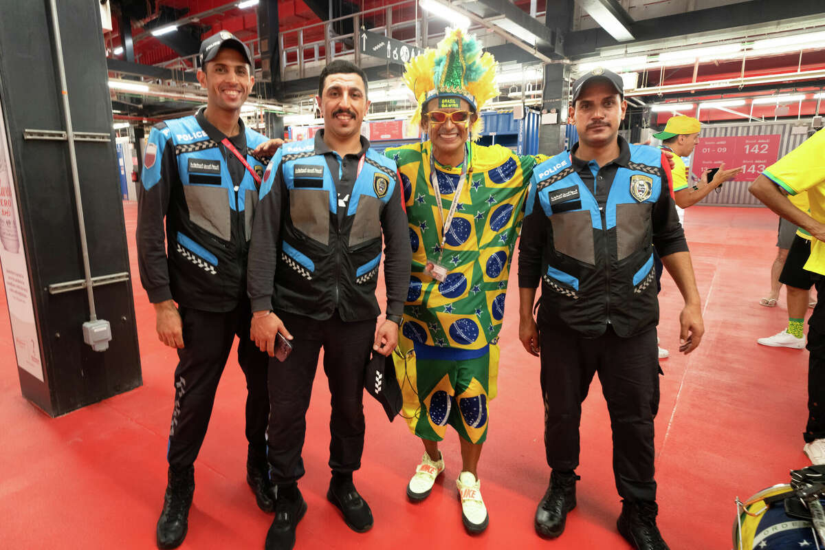 Three police officers pose for a photograph with Brazilian Wallace Leite after the Brazil and South Korea World Cup game at Stadium 974 in Doha, Qatar on December 5, 2022.