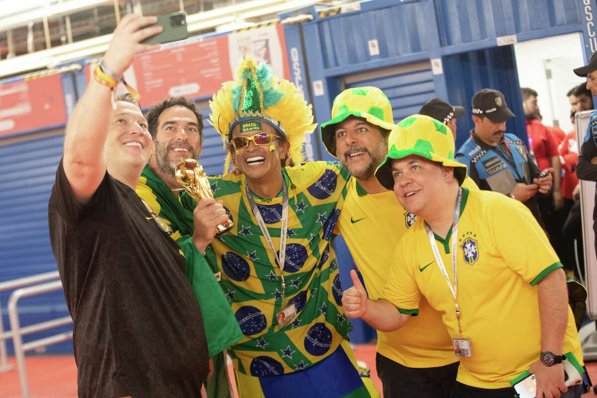 Brazilian Wallace Leite (center) poses with some fans for a photograph after the Brazil and South Korea World Cup game at Stadium 974 in Doha, Qatar on December 5, 2022.