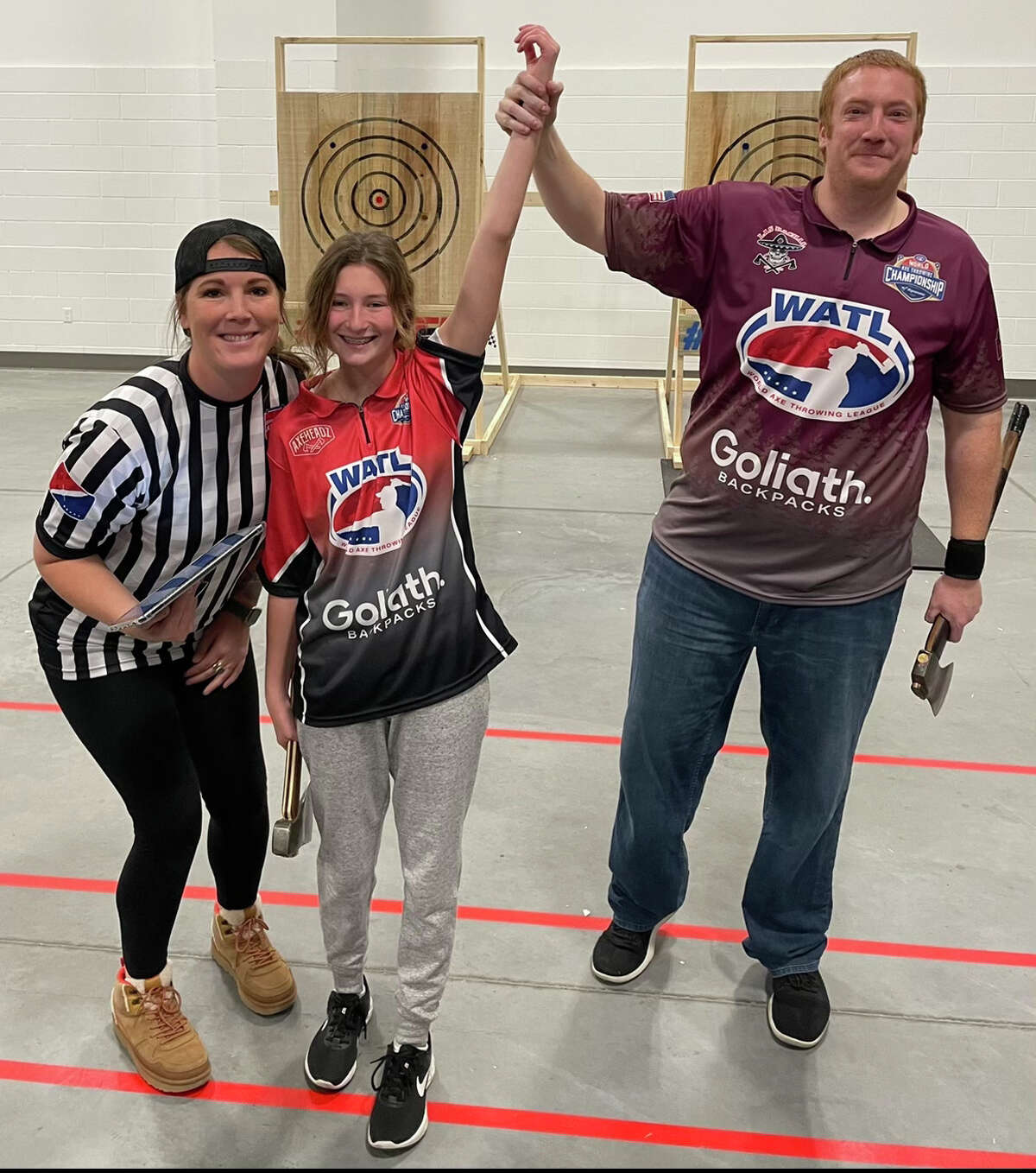 Josselyn Allen, 14, of Jerseyville attends the World Axe Throwing League World Axe Throwing Championship in Appleton, Wisconsin. She celebrates after her first match against Mark Tishko, the U.S. champion in hatchet. Judge Kasey Jennings (left) is a friend and sponsor.