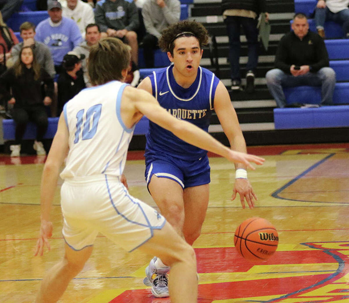 Marquette Catholic's Parker Macias brings the ball upcourt against Jersey's Drake Goetten (10) in a Roxana Tourney game last month. On Tuesday, Macias scored 19 points in the Explorers' GMC win over Father McGivney in Alton.