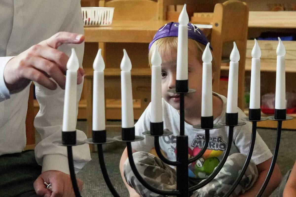 Rabbi Ranon Teller gives a lesson on Hanukkah to a class of 3-6-year-old children at Goldberg Montessori School on Thursday, Dec. 8, 2022 in Houston. Congregation Brith Shalom shares the campus with the school.