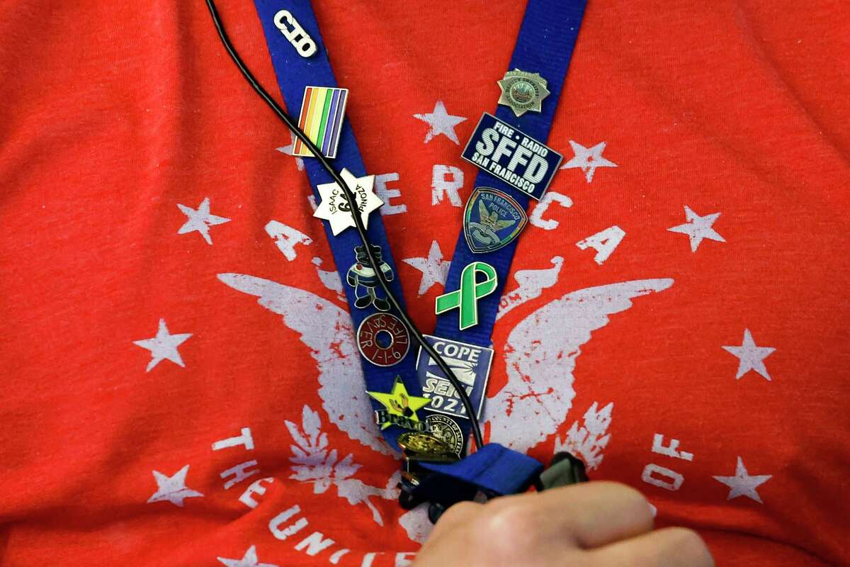 Ron Davis, a 911 dispatcher, wears a lanyard with pins from emergency agencies at the Department of Emergency Management in San Francisco.