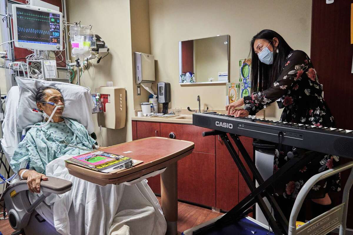 Houston Symphony first violinist Christopher Neal and the Center for Performing Arts Medicine program's Dr. Mei Rui perform for Gonzalo Alvarado in the intensive care unit at Houston Methodist Hospital.