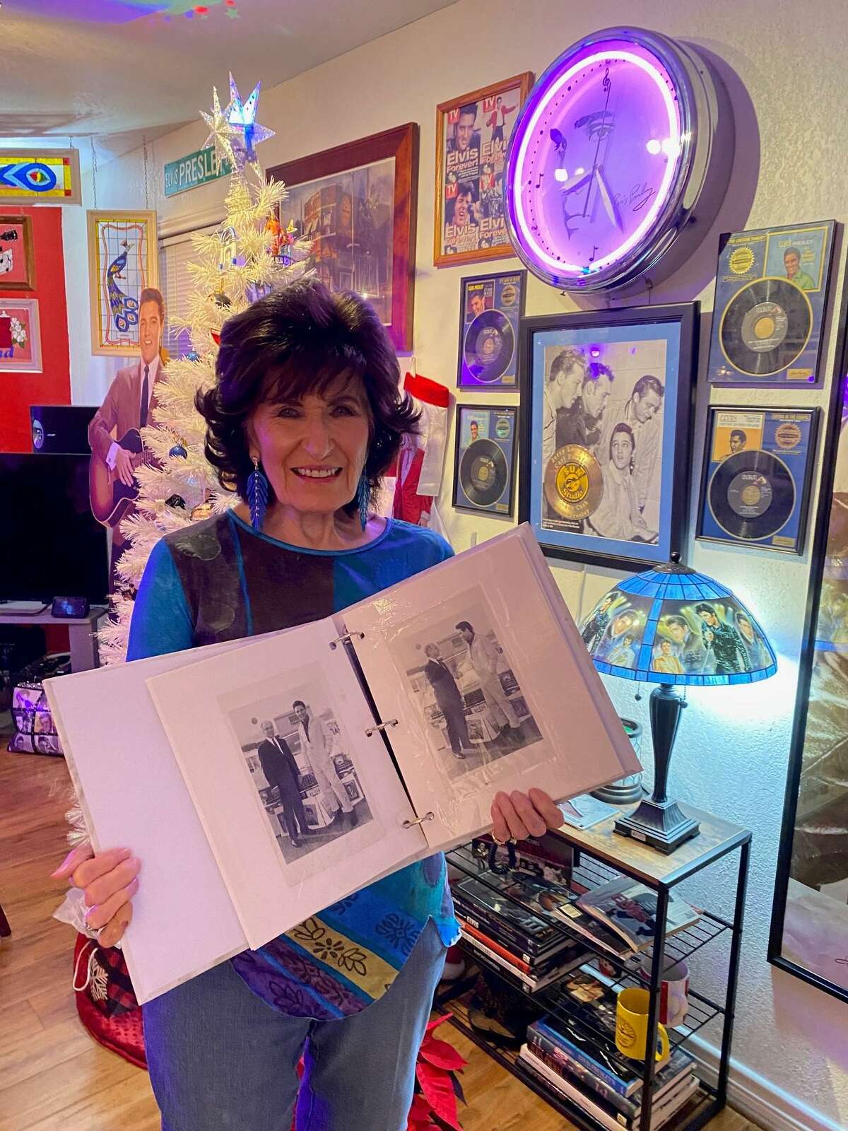 Conroe radio personality Mary McCoy, 85, holds up pictures of her manager, Gabe Tucker, and Elvis in her Elvis room.