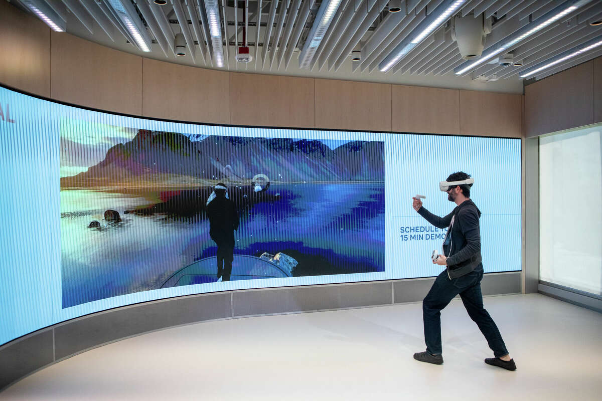 SFGATE culture editor Dan Gentile tries out the game SuperNatural on the Oculus Quest 2 virtual reality headset at the new Meta Store in Burlingame, Calif. on May 4, 2022. The game was broadcast on a large screen in the Meta Store.