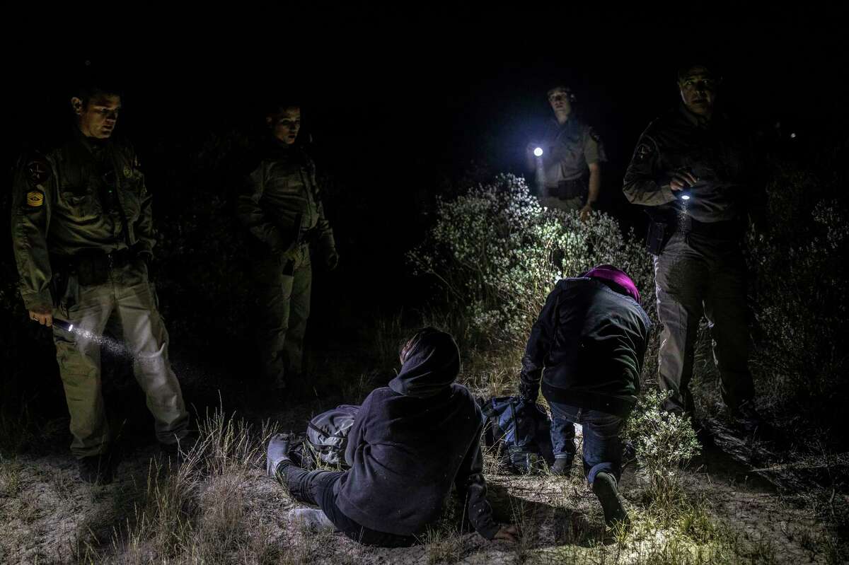 Texas Department of Public Safety officers apprehend a pair of migrants from Honduras on private ranch land in Kinney County on Nov. 16, 2021. In a significant win for Gov. Greg Abbott’s Operation Lone Star, the Texas Court of Criminal Appeals has ruled unanimously that Travis County courts can’t weigh claims of wrongful detention caused by misdemeanor arrests in Kinney County.