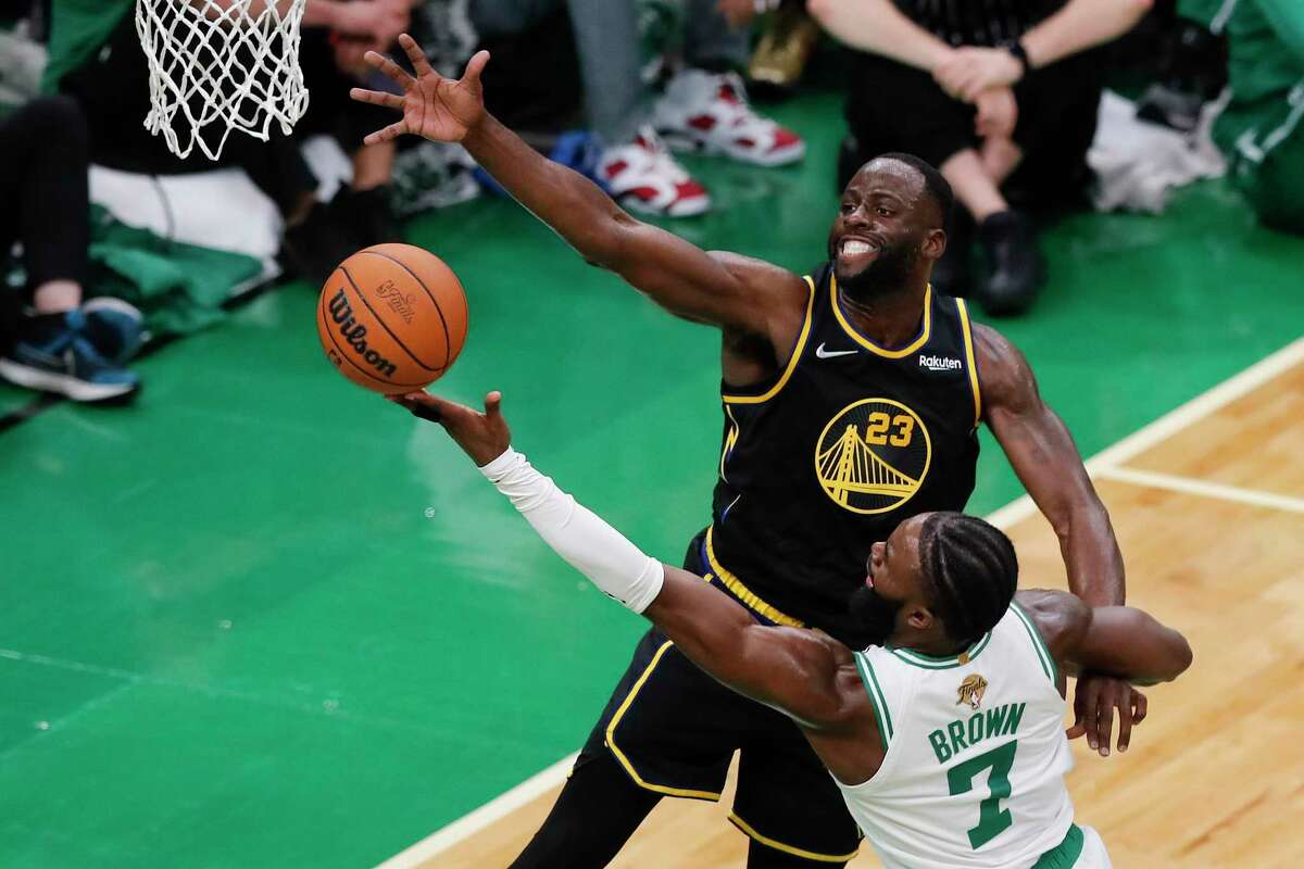 Boston Celtics guard Jaylen Brown (7) puts up a shot against Golden State Warriors forward Draymond Green (23) during the second quarter of Game 4 of basketball's NBA Finals, Friday, June 10, 2022, in Boston. (AP Photo/Michael Dwyer)