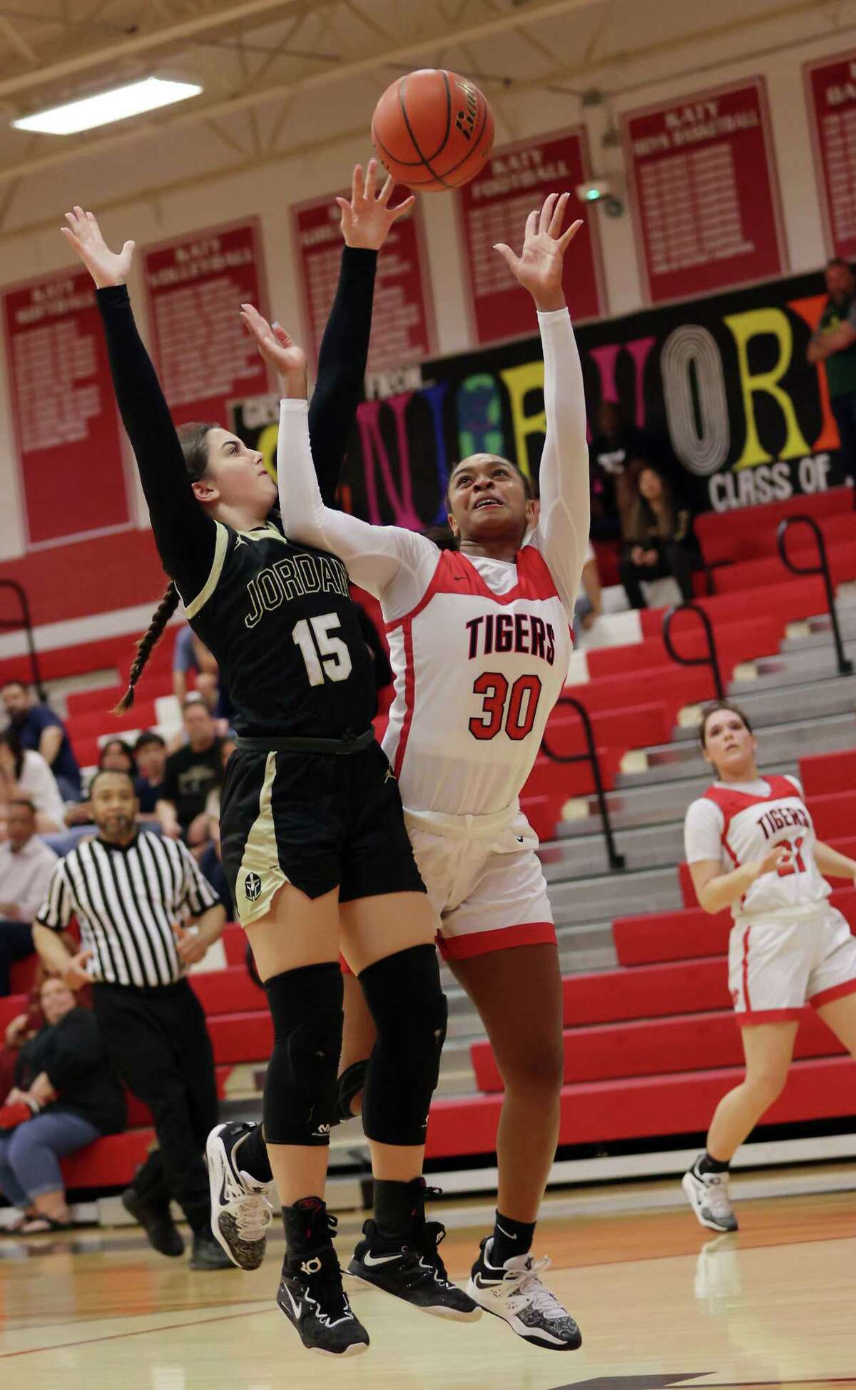 KATY, TX -DECEMBER 9: Katy Tigers Lyric Barr (30) drives to the basket on Jordan Warriors Allie Hakinzadeh (15) during a District 19-6A girls basketball game between Jordan and Katy December 9, 2022 in Katy,Texas.