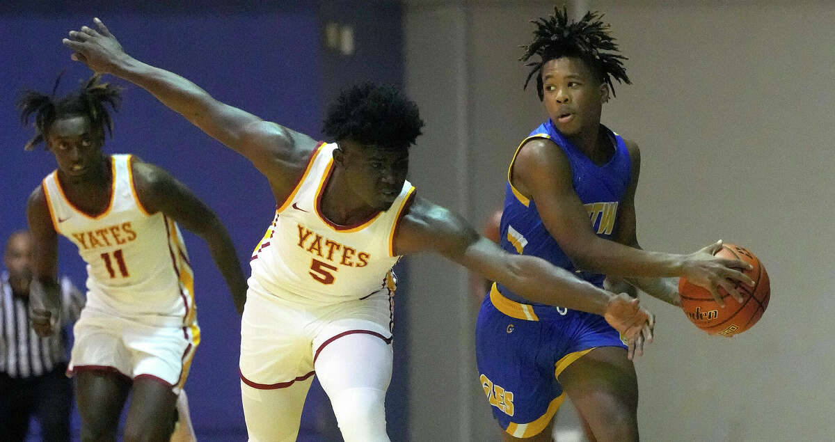 Yates Deshon Scott (5) reaches for a ball against Washington's Odis Carter (3) during the first half of a high school District 21-4A boys basketball game at Barnett Fieldhouse on Friday, Dec. 9, 2022 in Houston.
