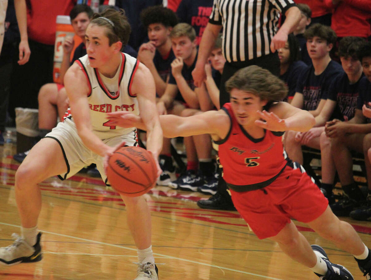 Big Rapids' Riley Vennix (right) tries to take the ball away from Reed City's Aiden Storz during Friday's basketball game.