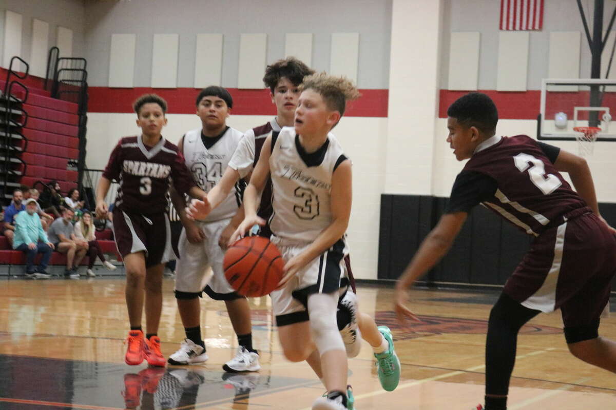 San Jacinto Intermediate 7A player Kason Edwards splits the Seabrook Spartan defense in going for two of his points Friday night. Kason and the Tigers will play two more games on Saturday to finish the tourney.