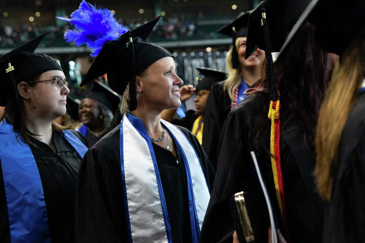 Graduates of College of Humanities and Social Sciences and College of Public Service at the University of Houston-Downtown walks toward their seats before the graducation commencement Saturday, Dec. 10, 2022, at Minute Maid Park in Houston. 2,500 students graduated from the school this semester.