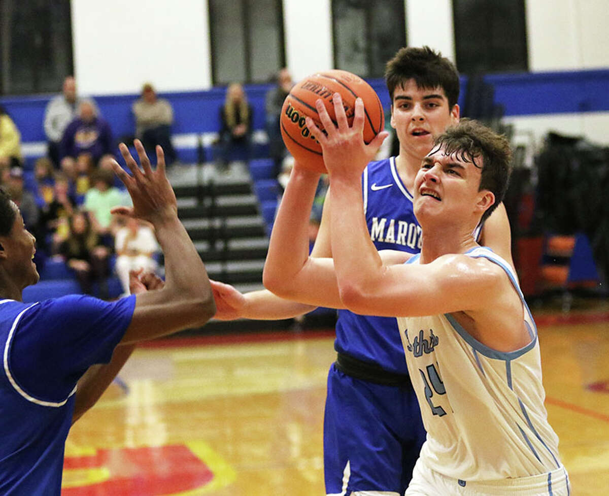 Jersey's Ayden Kanallakan (right) takes the ball to the basket against Marquette Catholic's Jack Spain (back) and Jaden Rochester in a Roxana Tourney game last month. On Friday, Kanallakan scored 21 points in the Panthers' MVC win at Highland.