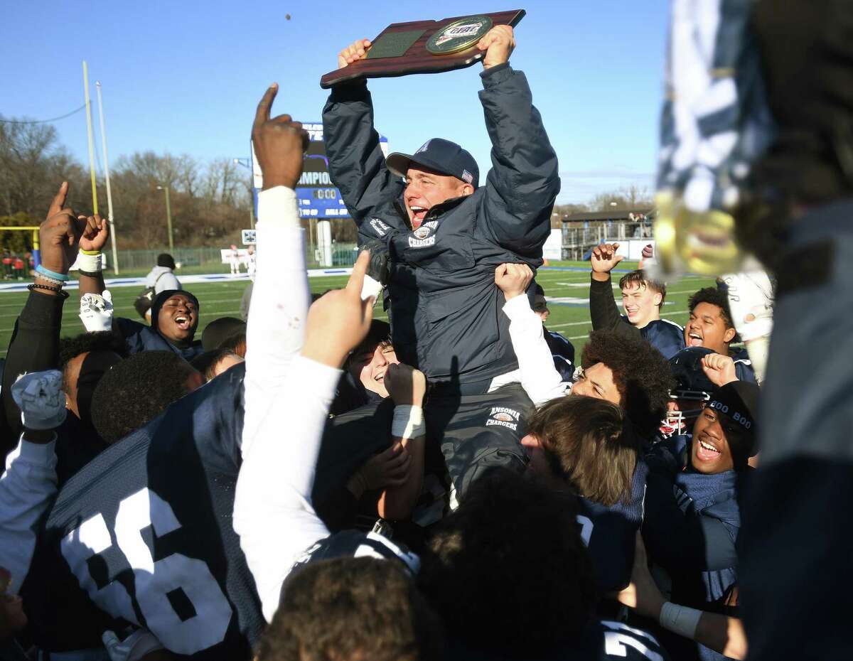 Ansonia football Coach Thomas Brockett is lifted in the air by his team following their 28-21 victory over Bloomfield in the CIAC Class S state football championship game at Arute Field at CCSU in New Britain, Conn. on Saturday, December 10, 2022.